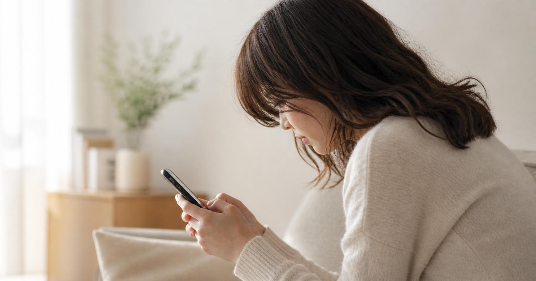 スマホのLINE返信を考えすぎて首や肩に力が入っている女性